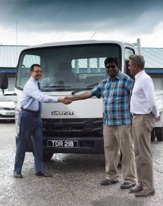 (Left to right) Imtiaz Ahamad, Managing Director of Southern Sales and Service Company Limited (Southern Sales), shakes hands with Rishi Ramroop of 4R’s Hardware in Gasparillo at the handover of an Isuzu NPR82U compressed natual gas (CNG) truck at Southern Sales' San Fernando dealership. Looking on is Curtis Mohammed, President of the NGC CNG Company Limited (NGC CNG). 

Southern Sales, local agents for Japanese vehicle manufacturer Isuzu Motors, has introduced a Medium Duty 100 percent CNG truck.
The Isuzu NPR82U CNG truck is currently available as a Demo unit to be test driven by various commercial operators, since this is the first OEM CNG Medium Duty commercial vehicle of its kind in Trinidad and Tobago. PHOTO COURTESY NGC CNG.