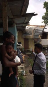 Alana Mayers and her 3-month-old baby girl Annesha Francis talking with Siparia Regional Corporation Chairman Dr GLEN Ramadharsingh at her home in Aripero Village, Rousillac, in the aftermath of a freak storm which tore off her roof yesterday.