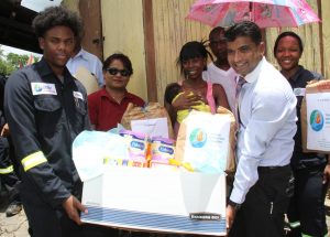 RELIEF: Left to right, J Huggins from Trinidad Generation Unlimited, Councillor for Rousillac Chanardaye Ramadharsingh, Alana Mayers and her baby Annesha Francis, who the hamper was donated to and Chairman of the Siparia Regional Corporation Glenn Ramadharsingh yesterday take time out for a photograph yesterday during a hamper distrubution in the Aripero area.PHOTO BY ANIL RAMPERSAD