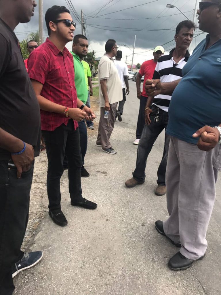 Councillor Chris Hosein (second from left) chats with taxi drivers and residents of Iere Village, Princes Town who are protesting the deplorable condition of the Naparima Mayaro Road in their area.