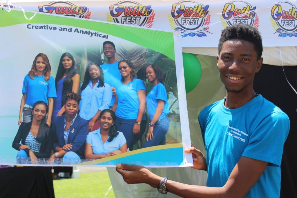 CAMPUS LIFE: Keston Reyes, a member of the UWI Communication Studies Association holds a section of their banner at UWI Guild Fest 2017.    PHOTO BY STEFFON DOUGLAS