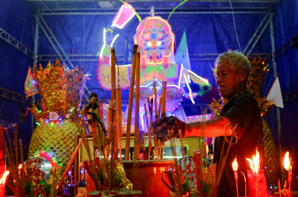 A man collects joss sticks in front of a giant paper statue of the Chinese deity “Da Shi Ye” or “Guardian God of Ghosts” during the Chinese Hungry Ghost Festival in Kuala Lumpur, Malaysia, yesterday. The Hungry Ghost Festival is celebrated during the seventh month of the Chinese lunar calendar, when prayers are offered to the dead and offerings of food and paper-made models of items such as televisions, refrigerators and sport cars are burnt to appease the wandering spirits.