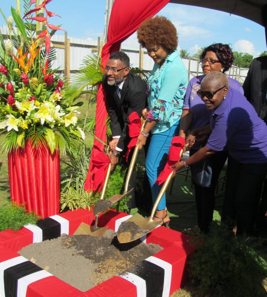 Sean Fouche, Divisional Manager - Corporate Services at the Urban Development Corporation of Trinidad and Tobago, left, and members of the Bon Air Gardens Community Council, at right, assist Minister of Community Development, Culture and the Arts, Dr Nyan Gadsby- Dolly at Tuesday’s sod-turning to mark the start of construction of the Bon Air South Community Centre.