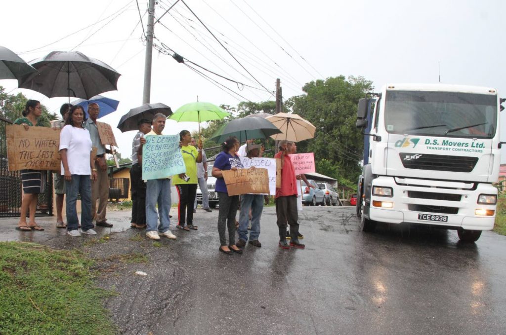 Residents of Robert Village, Tableland brave the rainy conditions yesterday to protest the deplorable road conditions in their area.