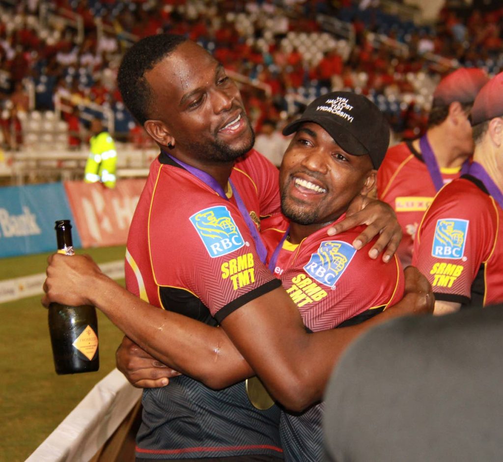 Trinbago Knight Riders’ Darren Bravo, right, hugs Man of the Match Kevon Cooper after their victory in the Hero CPL final early Sunday morning at the Brian Lara Academy, Tarouba.