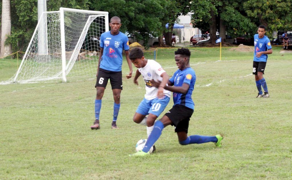 Naparima College's Mark Ramdeen, centre, is marked closely in a Secondary Schools Football League (SSFL) Premier Division match at Lewis Street, San Fernando, yesterday. Naps won 2-0. 