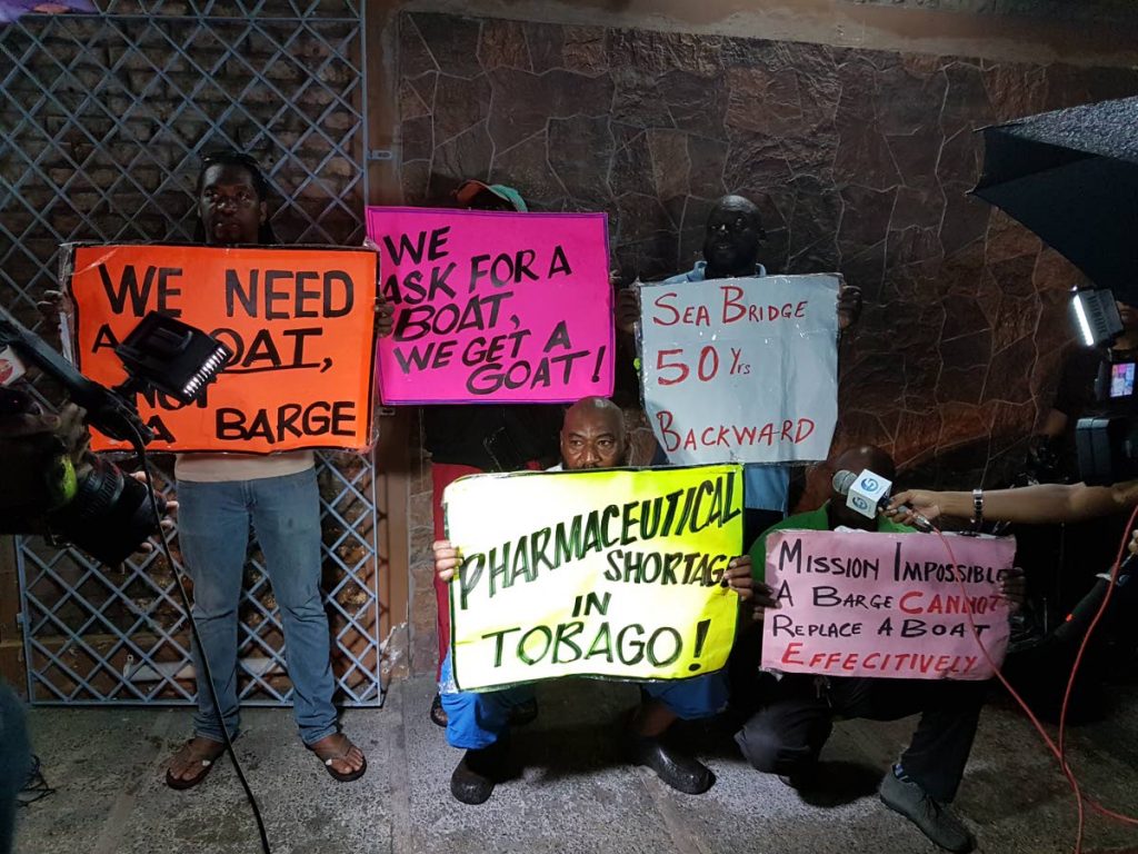 Truckers and traders who transport cargo on the inter-island transport route display protest placards on the inefficiency of the sea bridge in May this year at the Scarborough Port.
