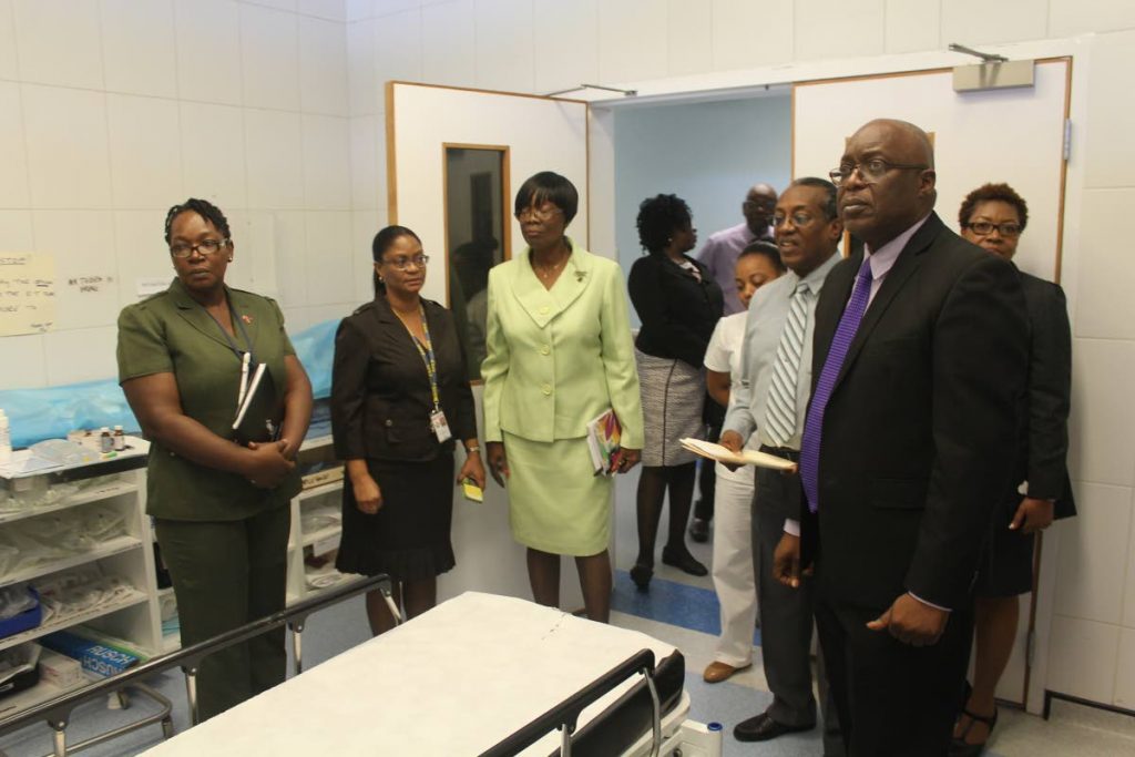  Chief Secretary of the Tobago House of Assembly, Kelvin Charles, right, on his first tour of the Scarborough General Hospital since assuming the post, stand with Health Secretary Dr Agatha Carrington, along with staff of the Tobago Regional Health Authority (TRHA) during a tour of one of the emergency rooms at the Hospital on September 6. Charles was apprised of plans to repair and upgrade some areas for some of the areas at the hospital. He visited the Accident &Emergency Department, the Mental Health Unit and the Surgical Ward.