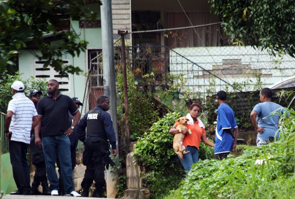BLOODY SCENE: Police and relatives at Kingston Avenue, La Canoa, Santa Cruz, the scene of the shooting death of Jason Thomas, and three other men who are hospitalised with gunshot wounds.