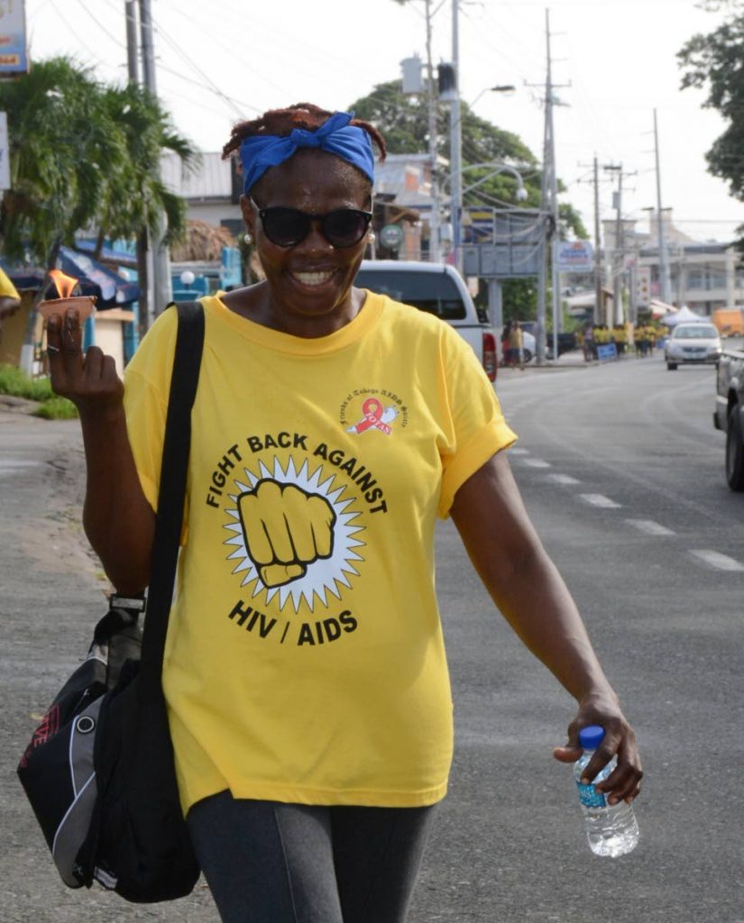 A woman walks with a lighted deya to honour the memory of persons who have died from AIDS as she participated in Mondays Walk against HIV/Aids from the Dwight Yorke stadium in Bacolet to Store Bay, hosted by Friends of the Tobago AIDS Society.