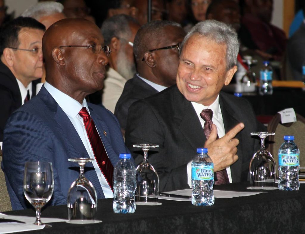 READY FOR MONDAY: Finance Minister Colm Imbert, right, speaks to Prime Minister Keith Rowley yesterday at a pre-Budget forum at the Hyatt Regency in Port of Spain. Imbert will deliver the National Budget on Monday in Parliament. 