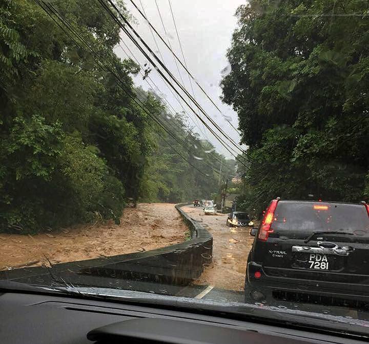 FLOODED: This photo, taken by a motorist and uploaded to the Facebook page of the Trinidad and Tobago Weather Centre shows Saddle Road in Maraval, right, under flood water next to the Maraval River which rose dangerously high following hours of heavy rainfall yesterday.  PHOTOS COURTESY TT WEATHER CENTRE
