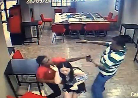 HERO ACT: Off-duty policeman Rory Manmohan, right, is seen in this freeze frame from CCTV video footage, shooting a bandit who held him and a woman hostage during a robbery on Thursday at a bar in Arima.