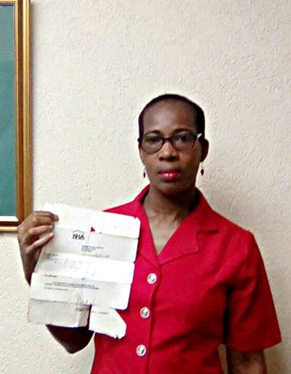 Beverly Mulraine shows an aged copy of a letter she received from the now defunct National Housing Authority from 1998, acknowledging receipt of her application.