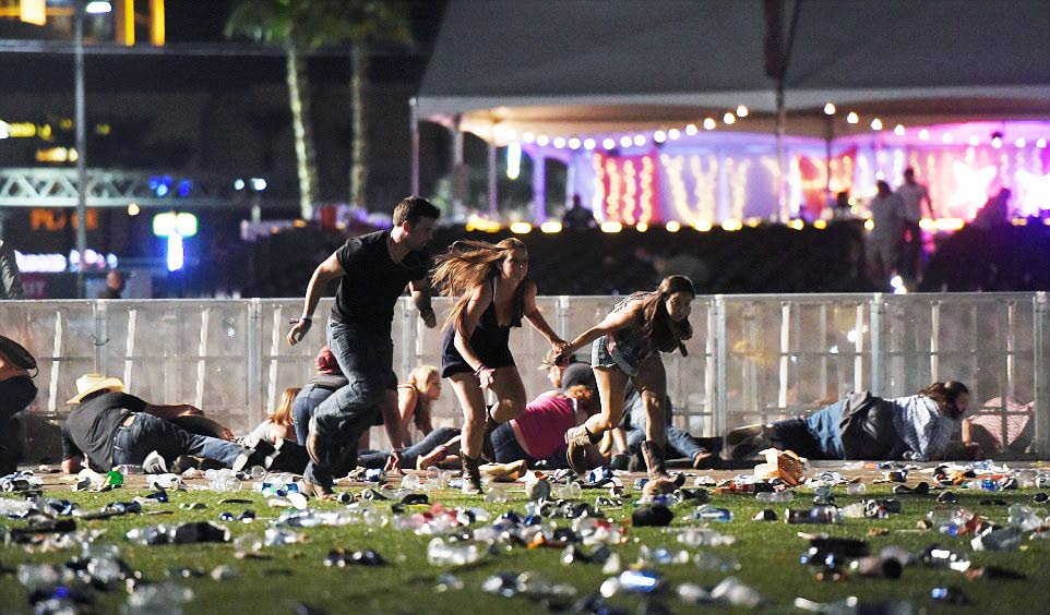 TAKING COVER: People run for their lives as shots are fired at an open air concert in Las Vegas Sunday night, leaving 58 dead and many hundreds injured. 