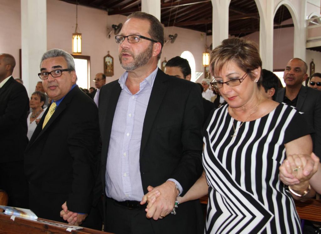 GOODBYE DADDY: (left to right) Bernard , Thomas and Anna Pantin join hands at the funeral for their father, former Fatima principal and  Minister of Education, Clive Pantin. Pantin was 84.
