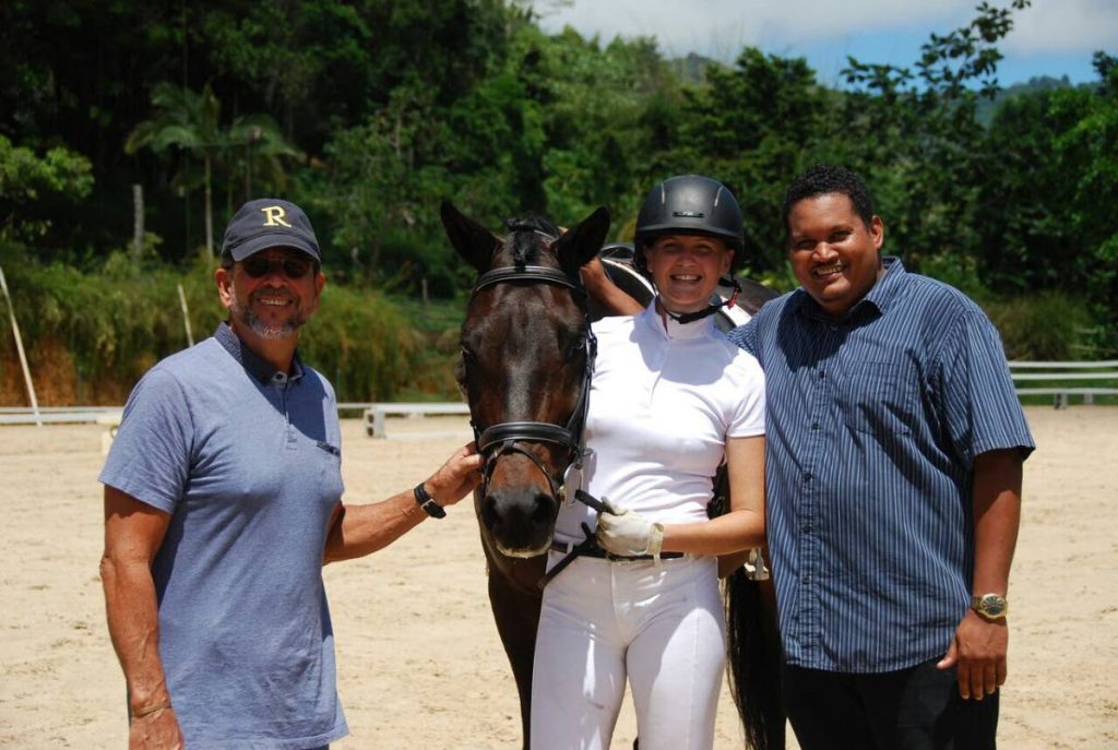 Sports Minister Darryl Smith (right) poses for a photo alongside TT Equestrian Association president Duglas Watsun (left) and rider Amy Costelloe with horse Claudio.