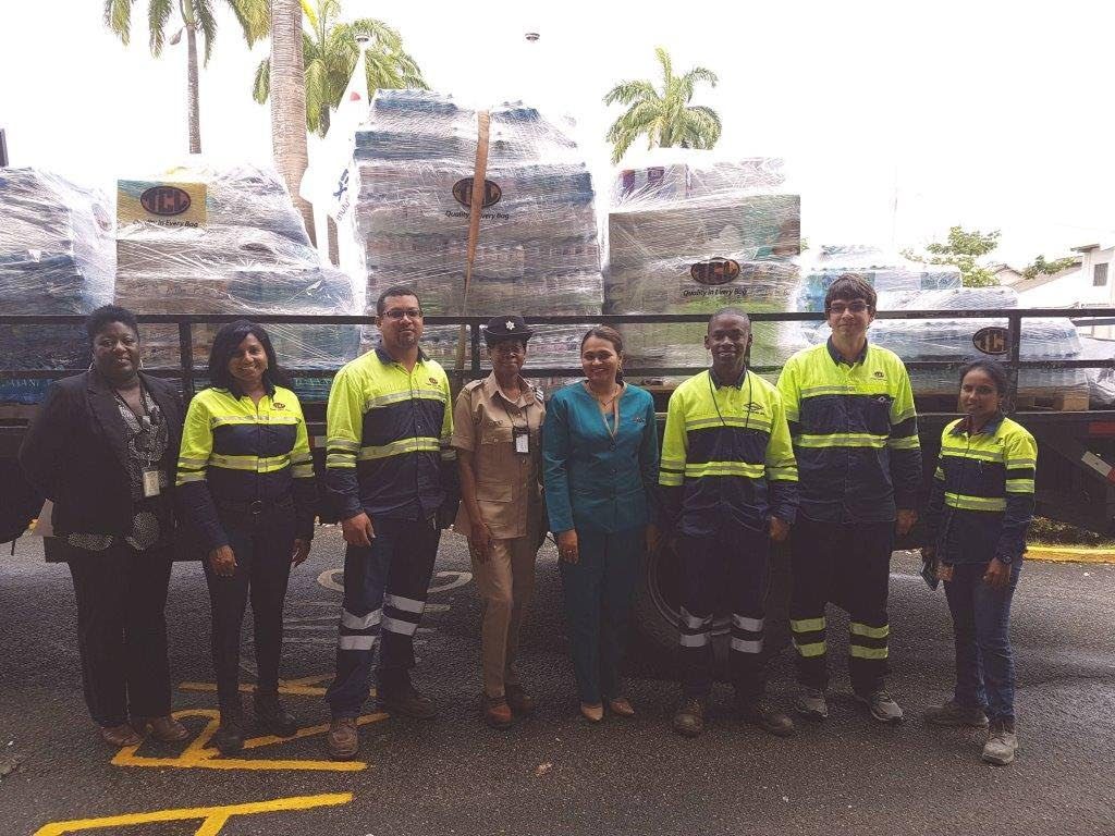 TCL employees standing in front of relief items for Dominica.
