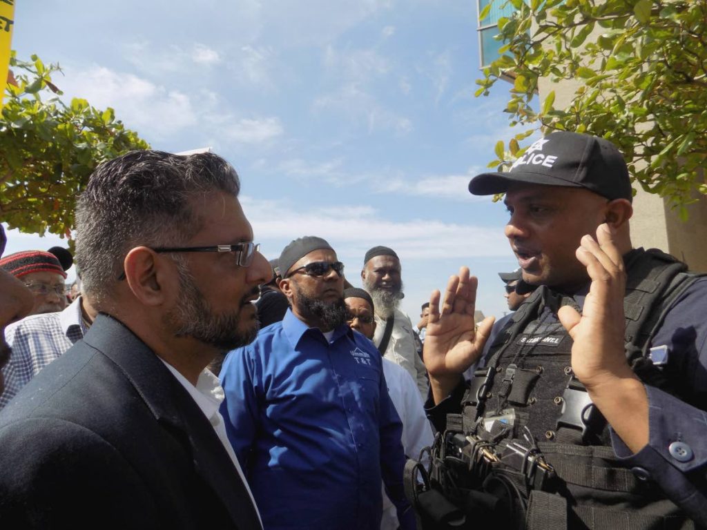 Former government Minister Devant Maharaj clashes with an officer from the Guard and Emergency Branch outside Tower D of Parliament at the International Waterfront in Port of Spain yesterday, as officers attempted to prevent protestors from gathering outside the chamber entrance.