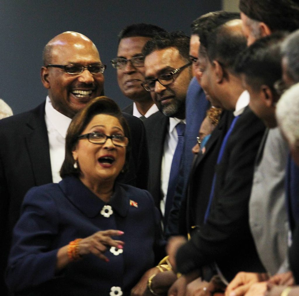 HELLO THERE: Opposition Leader Kamla Persad-Bissessar greets supporters as she walks past the public gallery in the Parliament Chamber on her arrival yesterday for the budget debate. Behind her is Senate Minority Leader Wade Mark.