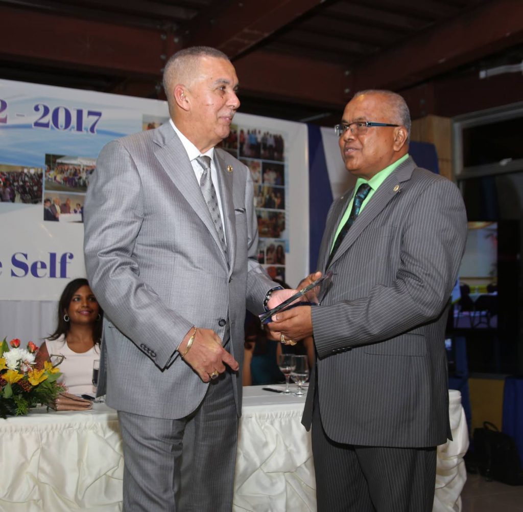 Suruj Mangaroo of the Rotary Club of Penal presents President Anthony Carmona, left, with an award during the Club’s 15th anniversary celebrations at Doc’s Ranch in Phillipine on the weekend.