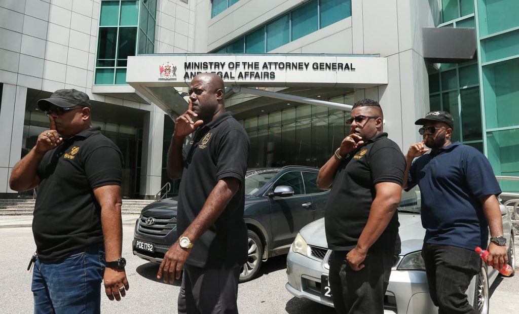 SILENCE: Members of the Prison Officers Association led by president Ceron Richards, right, in a silent protest outside the Office of the Attorney General in Port of Spain yesterday following the murder of a prison officer on the weekend. PHOTO BY AZLAN MOHAMMED