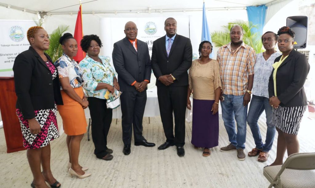 THA Chief Secretary Kelvin Charles, fourth from left, and Secretary for Settlements, Clarence Jacob, (centre) stand with new homeowners, from second from left, Natalie Chapman, Charmaine Louis, Carlene Toppin-Duke, Selwyn Archie and his wife Hayley, at a key distribution ceremony last Thursday for housing units at Dillon Crescent, Homes of Adventure, Phase II, Plymouth. Also in photo are the Divisions Administrator Denese Toby-Quashie, left, and Director of Settlements, Petunia Lewis, right
