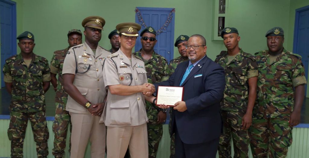  Commanding officer of the Regiment's First Engineering Battalion, Major Jerome Affonso, receives an appreciation award on behalf of soldiers who worked alongside volunteers on the Safe Shelter Through Landslide Mitigation project in Moriah from Derwin Howell,chairman of Habitat for Humanity Trinidad and Tobago.