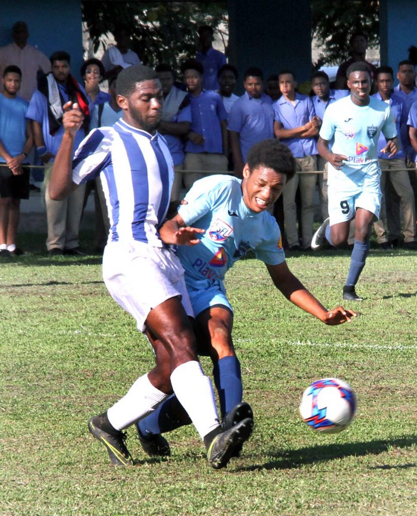St Mary’s Schileon Phillip, left, tackles QRC’s Kalev Kiel in a Secondary Schools Football League match yesterday at QRC Grounds, St Clair. St Mary’s won 3-1.