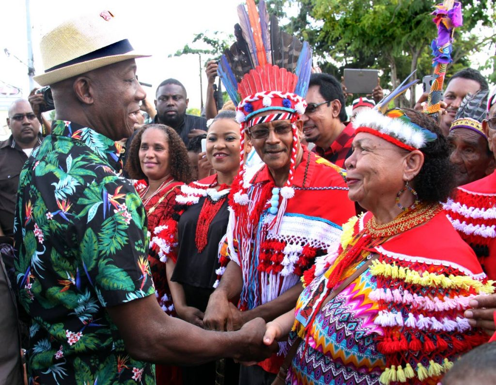 Prime Minister Dr Keith Rowley greets First Peoples Queen Valentina Medina, as head of the First Peoples Commuity Ricardo Bharath-Hernandez, members and government officials look on, before a parade in their honour in Arima yesterday.