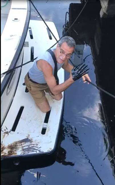 HAND SMEARED: Head of Fishermen and Friends of the Sea, environmentalist Gary Aboud shows the after effects of an oil spill near the Crews Inn marina at Chaguaramas over the weekend.
