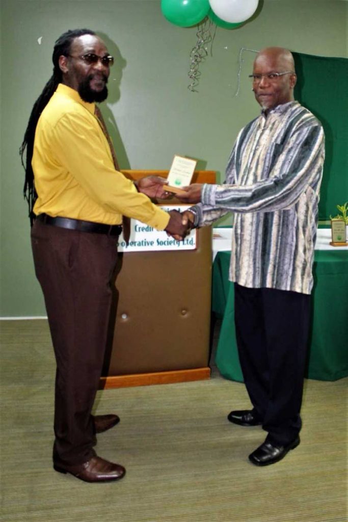 Past President Roland Graham receives his token from Nkoma Kamau.