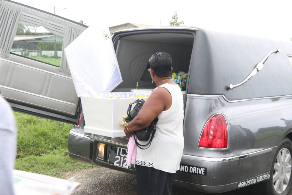 DEAD DEAD:A woman looks at the body of Radhay Kissoon, 69, who caused panic during his funeral yesterday when people noticed him ⁢'breathing' in the casket. He was taken to a health centre, pronounced dead again and brought back to the funeral which resumed and he was buried later. PHOTO BY ANSEL JEBODH