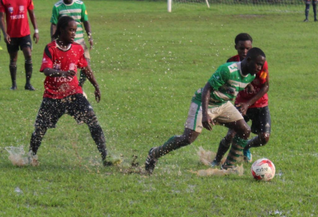 Samuel Anthony (centre) of St Augustine tries to evade the challenges of St Anthony's Che Benny (left) and Quinn Frederick during yesterday's SSFL Premier Division encounter at St Augustine.
