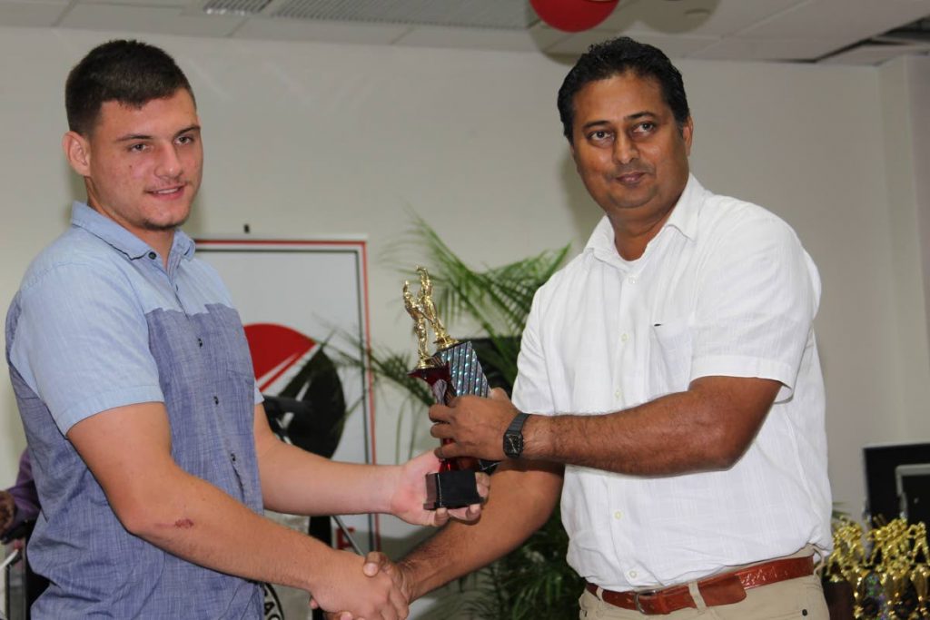 Joshua Da Silva (left) from Queen’s Park II receives an award from Anil Kamal at the Trinidad and Tobago Cricket Board’s 61st annual presentation function, at the National Cycling Velodrome, Couva on Saturday.
