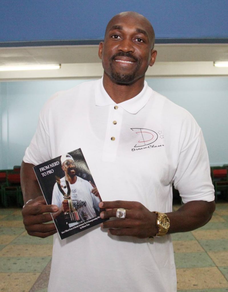 Former pro basketballer Kibwe Trim shows off his book at his alma mater St Mary’s College 
yesterday.