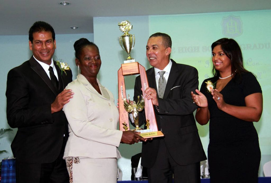 PROUD MOM: Brenda Roberts, second left, receives an award  from His Excellency President Anthony Carmona on behalf of her daughter Lexine, at Iere High’s graduation yesterday. At left stands school principal Roy Nandlal and at right is wife of the President Mrs Reema Carmona.