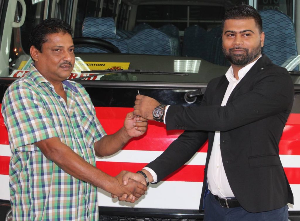 Fuelled up: Donald Lalloo receives the keys for one of the two first ever Fuso Rosa buses to use CNG fuel from Sajid Ali-Baksh, brand manager, ANSA Atomotive at Diamond Motors, Port of Spain yesterday.