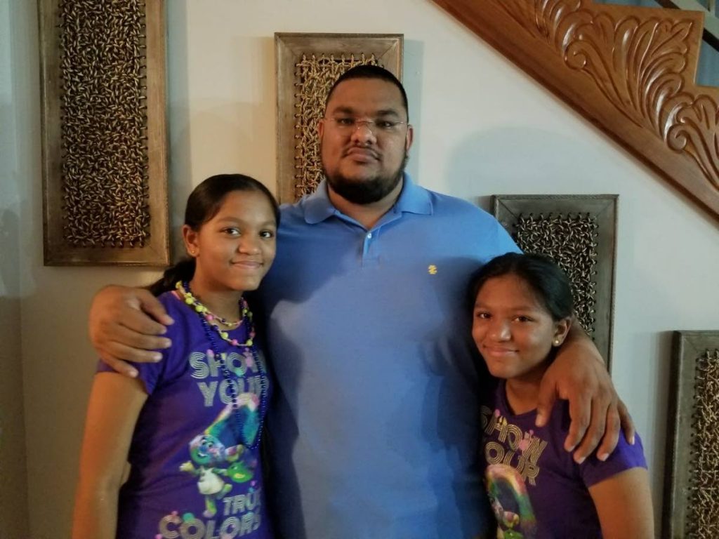 MOVED TO TEARS: Riaz Khan and his 10-year-old twin daughters Mariah and Mayah who have promised to build a house for Dave Nagoo, his wife Indira and three daughters who have been sleeping in a car since being evicted last week.