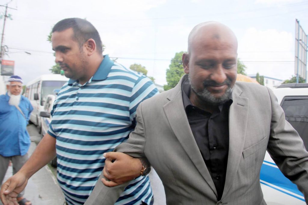 Businessman Inshan Ishmael is led to the Chaguanas Magistrate Court by PC Khan this afternoon. PHOTO BY Vashti Singh 