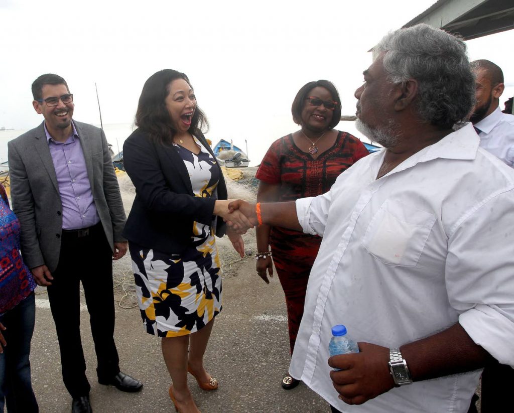 Rachel Moses, representative of Micosoft Caribbean shakes the hand of Keshore Boodram, president of the Claxton Bay Fisherfolk association, while Jean-Paul Dookie FUJITSU representative and Minister of Planning, Camille Robinson-Regis looks on at the launch of a Water Quality Monitoring Buoy. PHOTO BY Lincoln Holder
