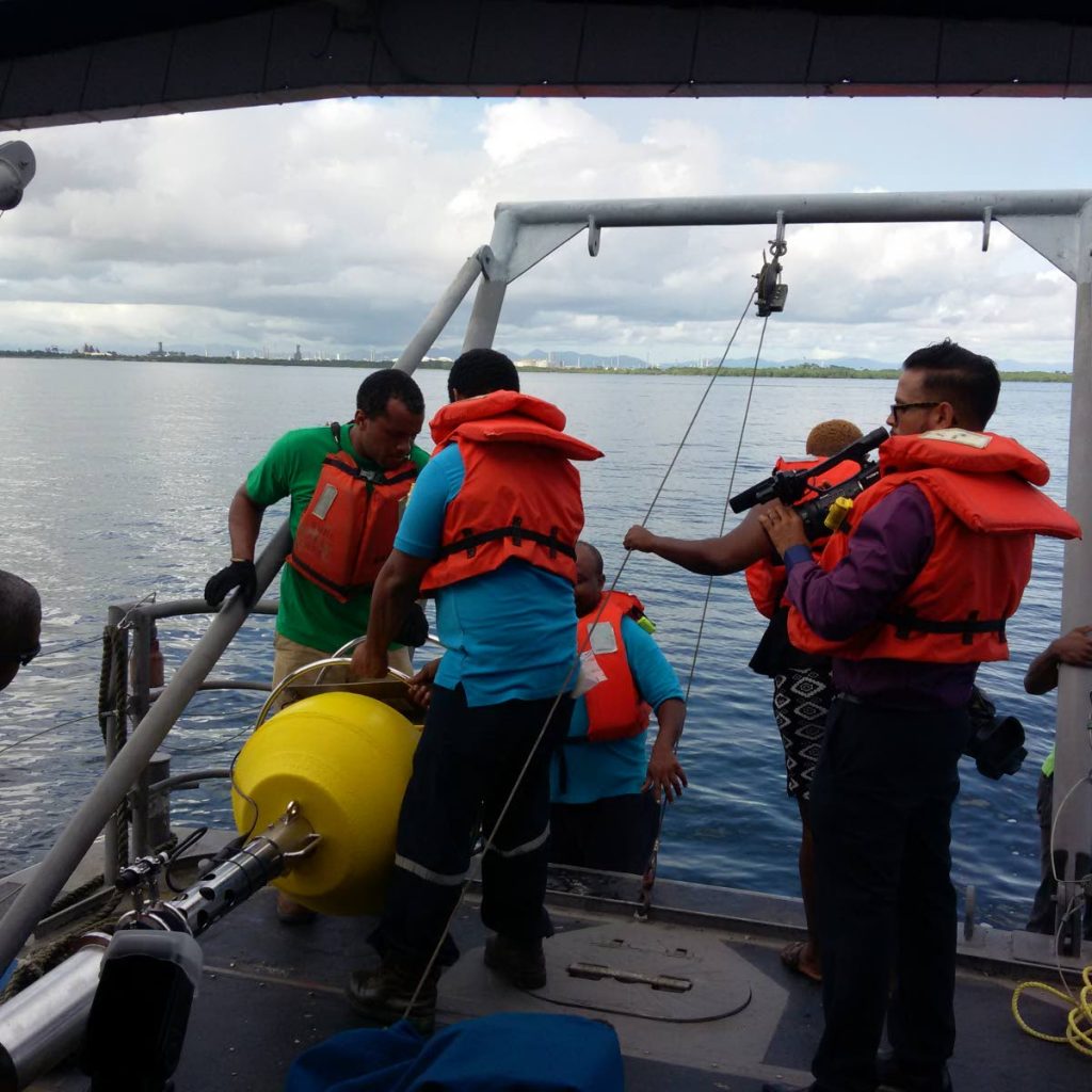 The Water Quality Monitoring Buoy being launched in the Gulf of Paria