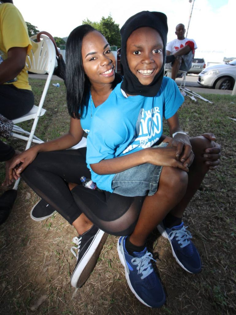In this November 4 file photo, Teniesha Elder and her son Rhenako Beard share a happy moment during a fundraiser for his cancer treatment at Nelson Mandela Park, Port of Spain.