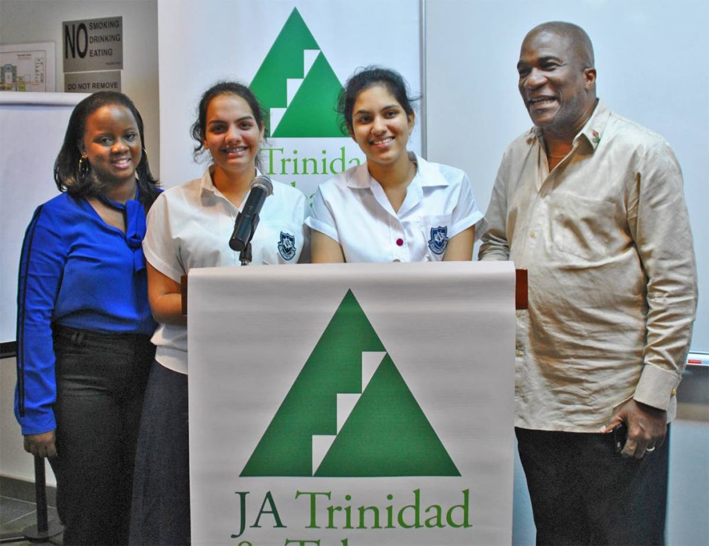 Naparima Girls’ Nirvana Maharaj (second from left) and Shreya Gopeesingh are congratulated by JA Executive Director J. Errol Lewis, after winning their round two session of the JA Leadership Debating Series on Thursday. Sharing in the moment is teacher Crystal Bastien.

