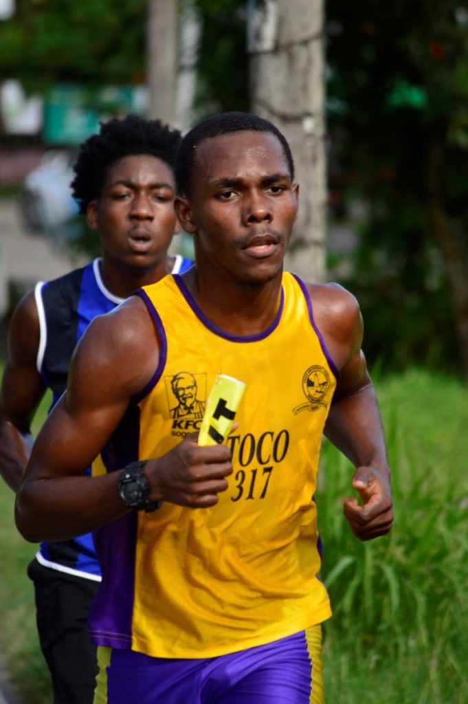 Toco Secondary’s Otis Barker, right, on his way to victory in the boys division of the Blue Waters Secondary Schools 5K Classic in Penal.