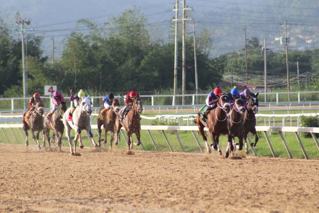 KERRON KHelawan (third right) on Conquest Beespoke edges Ronald Ali on Stockyard to win yesterday’s featire handicaop Race 7 at the Santa Rosa Track, Arima.