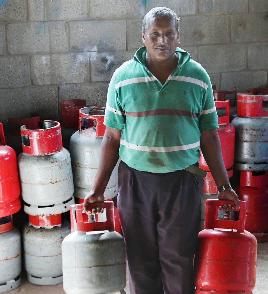 STOCKING UP: Robbie Sookoo leaves a Felicity supermarket with two tanks of LPG cooking gas yesterday.