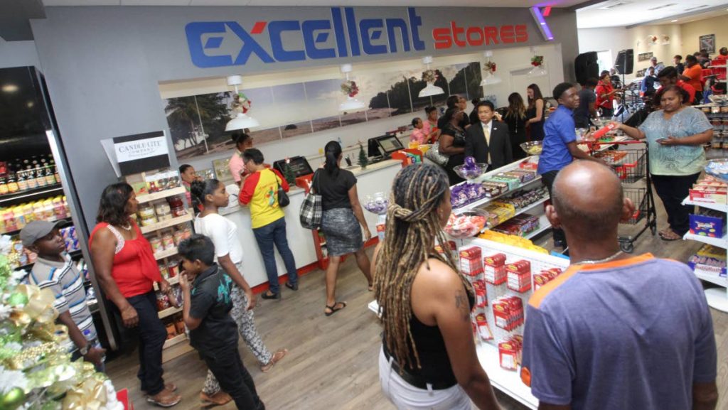 Franco Siu Chong, centre right, looks on as customers experience the grand opening of Excellent Stores’ new location in the Shops of Arima complex, Tumpuna Road, Arima, yesterday.