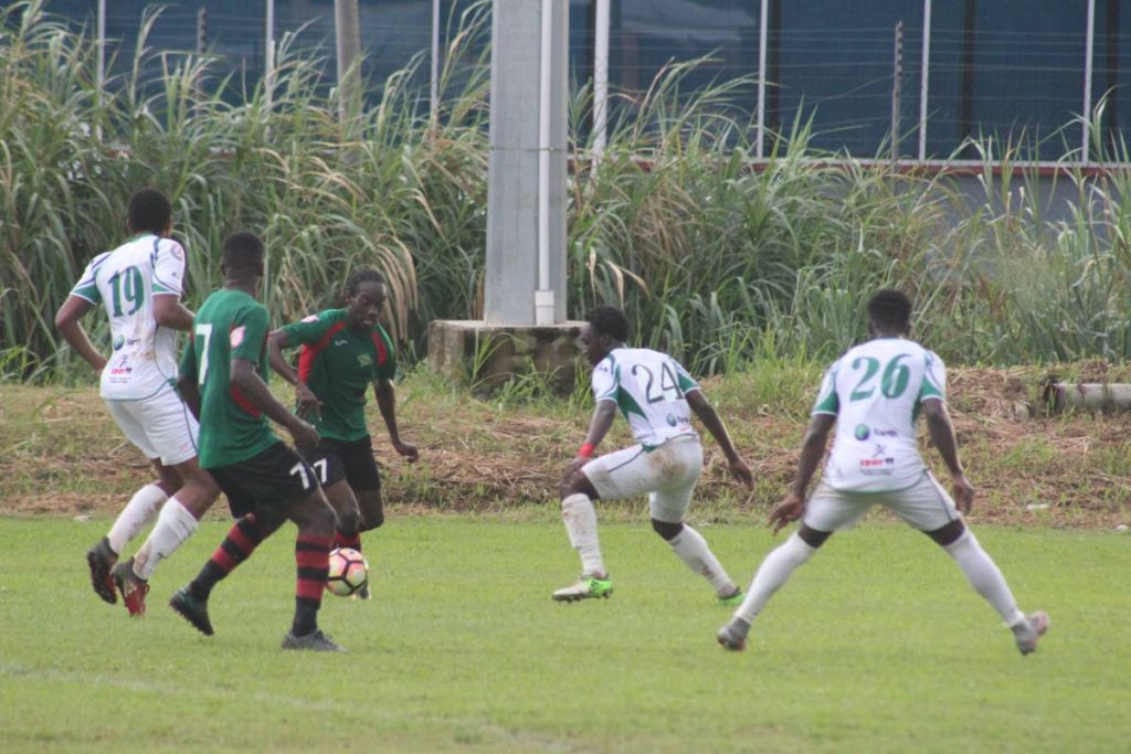 San Juan Jabloteh winger Nathan Lewis (centre) tries to get past a trio of W Connection defenders Briel Thomas (left), Jameel Antoine (second from right), and Isaiah Garcia (right), while fellow Jabloteh player Elijah Manners look on. Action was at the Barataria Oval on Monday.