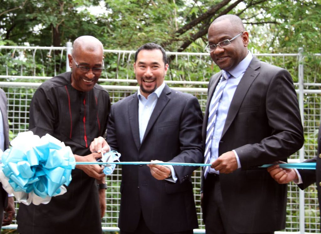 WATER WARNING: Public Utilities Minister Robert Le Hunte (left) assists Minister in the Office of the Prime Minister Stuart Young in cutting the ribbon to open the WASA McKai booster station in Belmont yesterday.  Looking on is WASA’s chairman Romney Thomas.